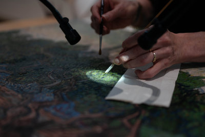 Paintings conservator Kathrin Pilz removes the varnish layer of Olive Grove with fine tools under the microscope. Photo: Isabell Janssen.