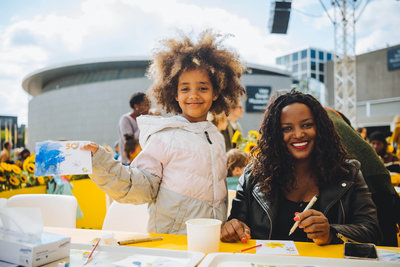 A smiling mother and her daughter are painting at the Sunflower Art Festival to celebrate the Van Gogh Museum's 50th anniversary on 2 June 2023. Photo: Jelle Draper