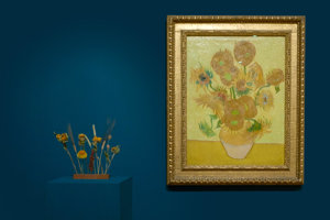 Close-up van de bloomon flowergram met droogbloemen voor het schilderij Zonnebloemen van Vincent van Gogh tegen een donkerblauwe muur