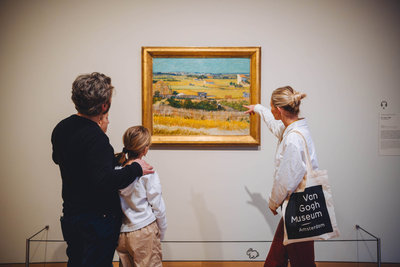 A family is looking at the painting The Harvest by Vincent van Gogh during a guided tour. Photo: Jelle draper