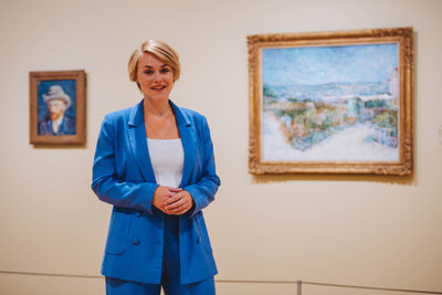 Van Gogh Museum Researcher Bregje Gerritse in front of Van Gogh's paintings 'Self-Portrait with Grey Felt Hat' and 'Montmartre: Behind the Moulin de la Galette'. Photo: Jelle Draper