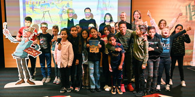 Groep 7 van basisschool Het Bovenland tijdens de boeklancering met het eerste exemplaar van De Grote Vincent van Gogh Atlas Junioreditie. Op de achterste rij, vlnr: Geert Gratama (illustrator), René van Blerk en Nienke Denekamp (auteurs), Mascha de Vries (uitgever) en Emilie Gordenker (directeur van het Van Gogh Museum). Foto: Floor Minnaert